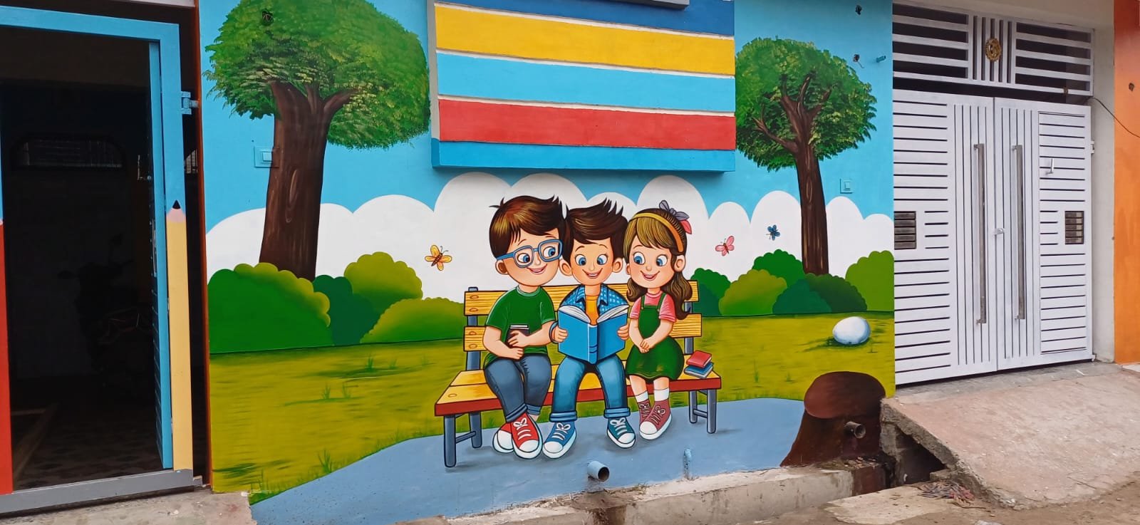 Hand-painted cartoon children reading books on an outdoor school wall
